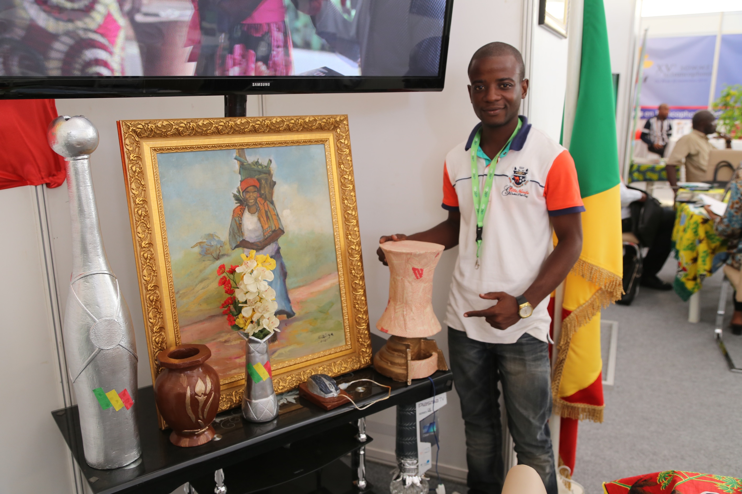 Divin Diakouika sur le stand du Congo au village de la francophonie de Dakar, entouré de ses créations en papier (©ADIAC)