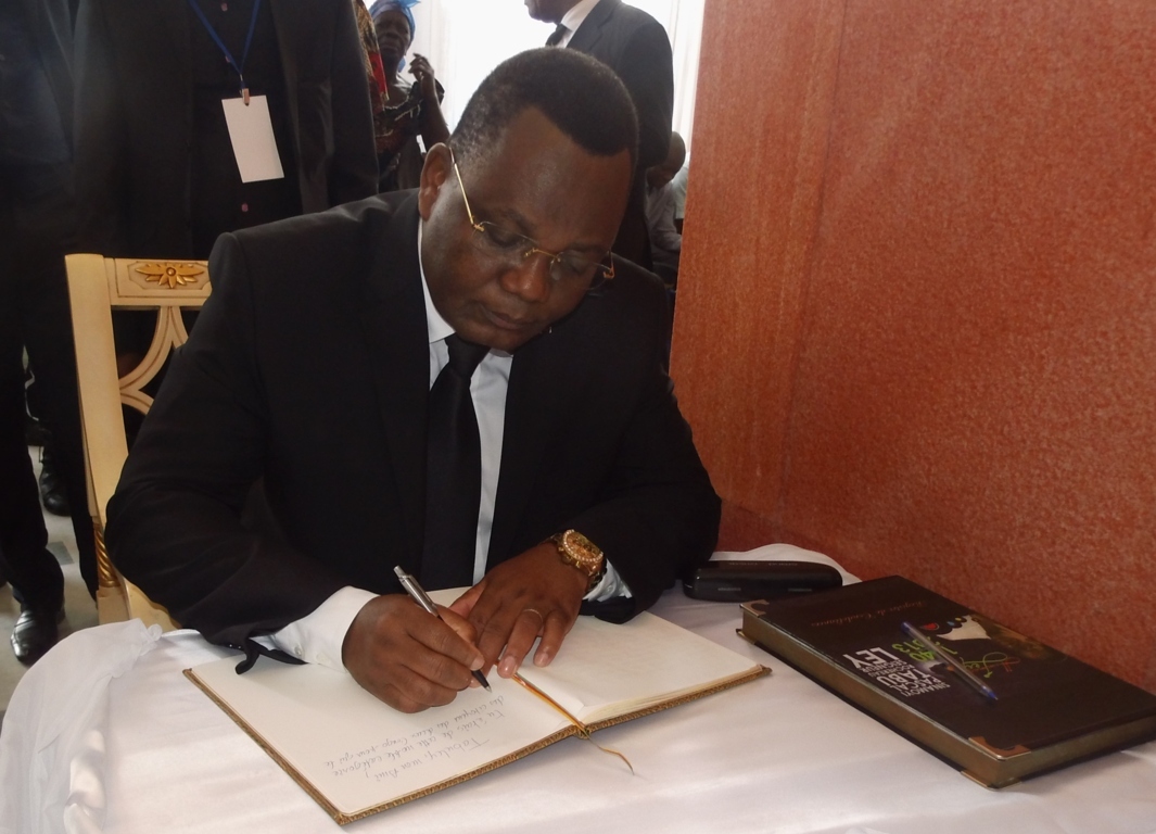 Le ministre de la Culture et des Arts signant le livre d'or en hommage à Tabu Ley